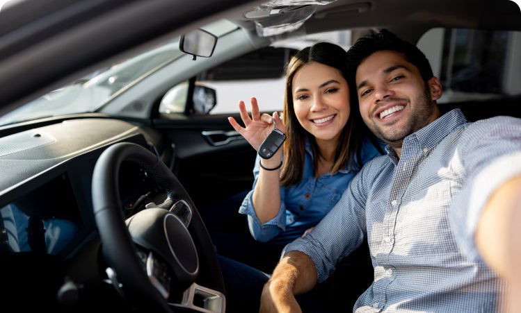 Couple with keys in hand while sitting in the vehicle
